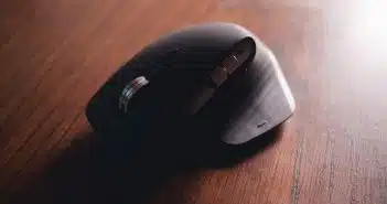 black cordless computer mouse on brown wooden table